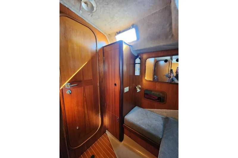Slide: The Image of Interior of 1988 Beneteau First 405 sailboat with wooden paneling and cozy seating area. - 24