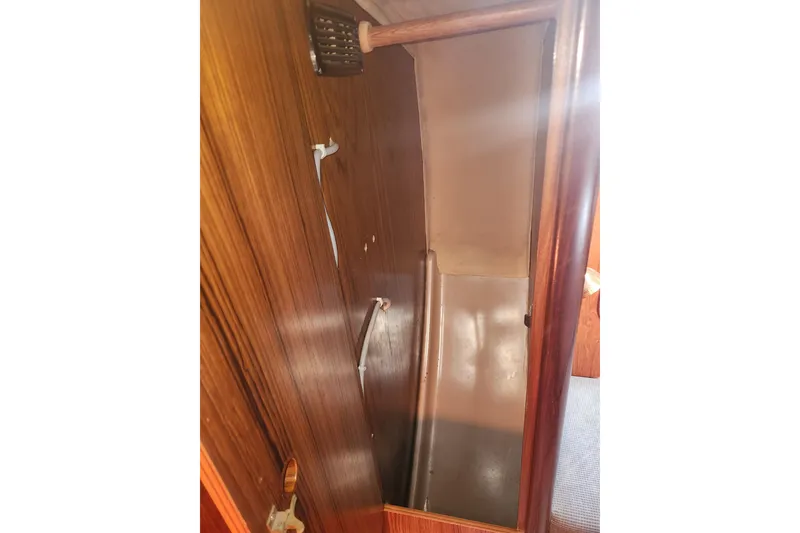Slide: The Image of Wooden interior of 1988 Beneteau First 405 sailboat, featuring a storage compartment. - 26