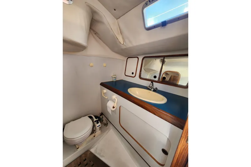 Slide: The Image of 1988 Beneteau First 405 yacht bathroom with sink, toilet, and mirror. - 28