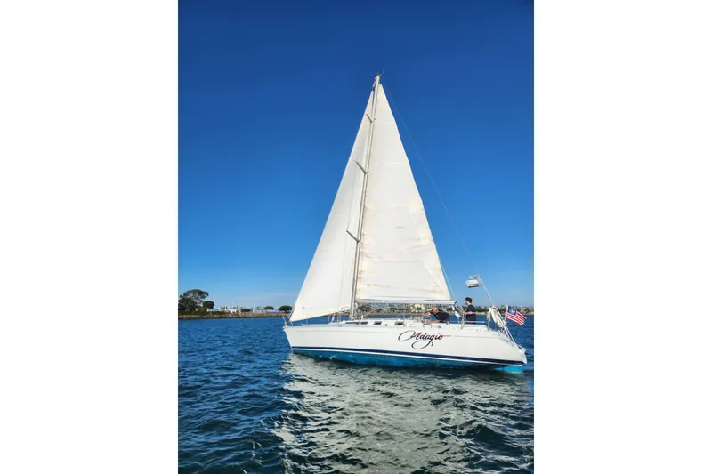 Slide: The Image of 1988 Beneteau First 405 sailboat on open water under clear blue sky. - 3