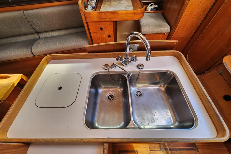 Slide: The Image of 1988 Beneteau First 405 yacht kitchen with double stainless steel sink and wooden cabinetry. - 30