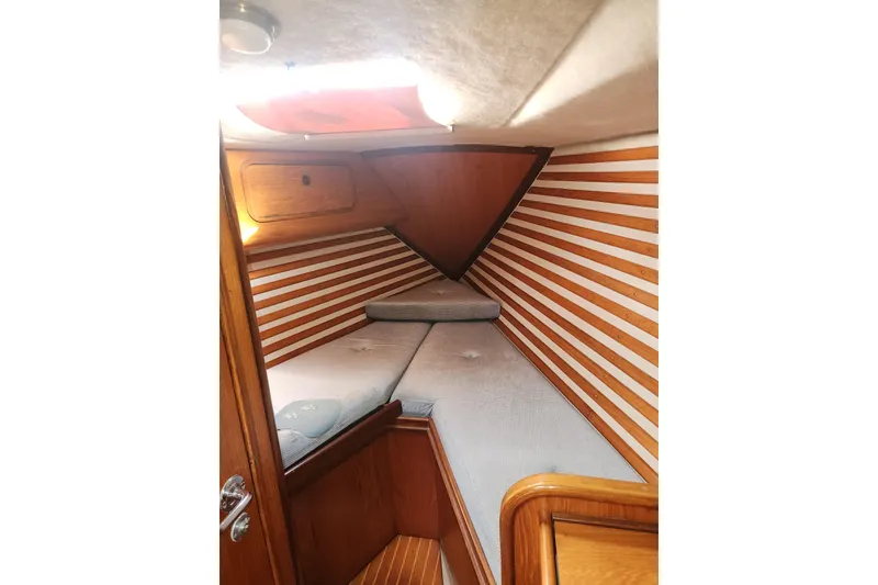 Slide: The Image of 1988 Beneteau First 405 cabin interior with striped wood paneling and cozy bedding. - 33