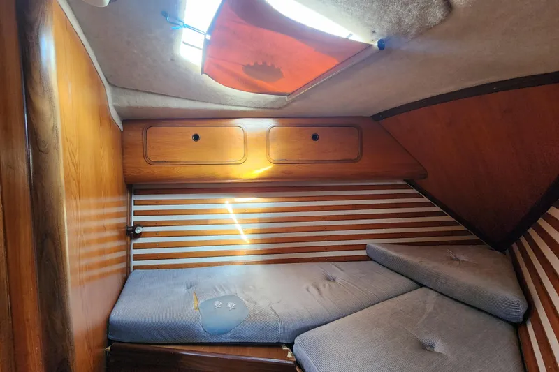 Slide: The Image of 1988 Beneteau First 405 cabin interior with wooden paneling and cushioned seating. - 38