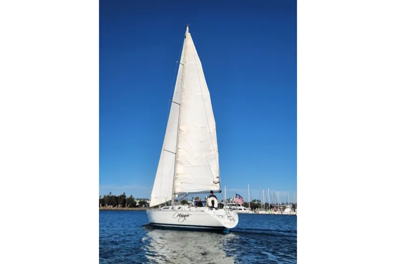 Slide: The Image of 1988 Beneteau First 405 sailboat on calm water under clear blue sky. - 4