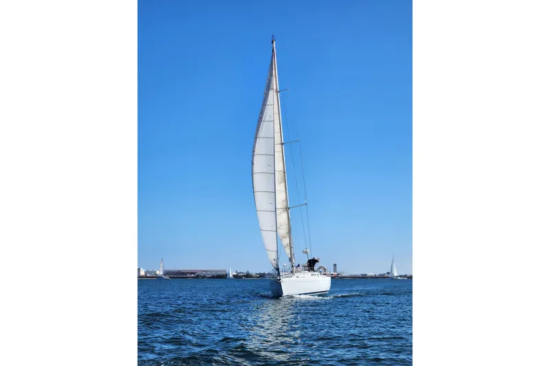 Slide: The Image of Sailing yacht Beneteau First 405, 1988 model, gliding on open water under clear blue sky. - 44