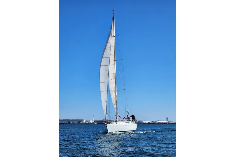 Slide: The Image of Sailing yacht Beneteau First 405, 1988 model, gliding on open water under clear blue skies. - 46