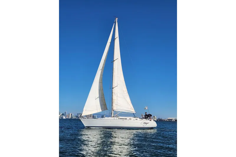 Slide: The Image of 1988 Beneteau First 405 sailboat on calm water under clear blue sky. - 48