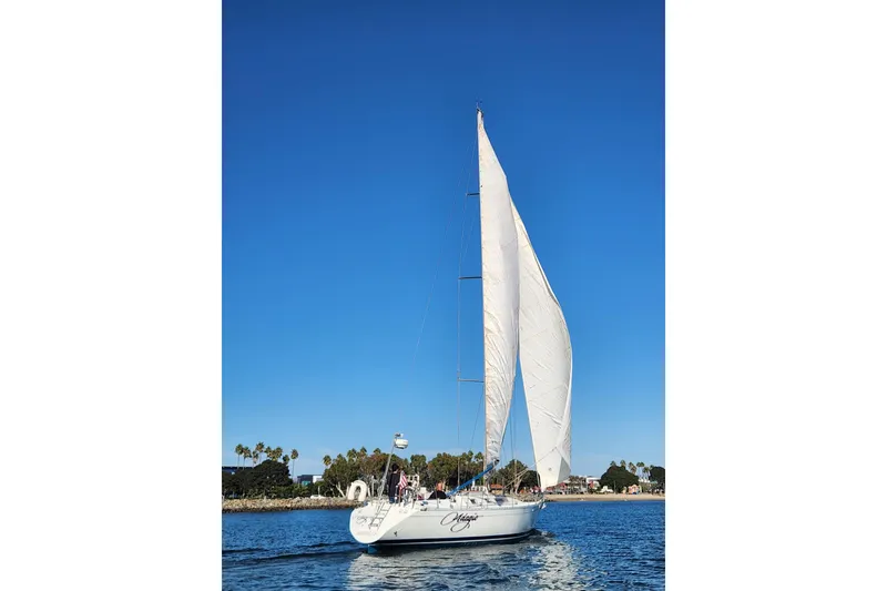 Slide: The Image of Sailing yacht Beneteau First 405, 1988 model, on calm waters under clear blue sky. - 52