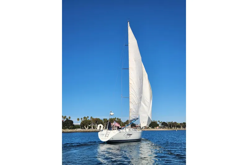 Slide: The Image of 1988 Beneteau First 405 sailboat on calm water under clear blue sky. - 53