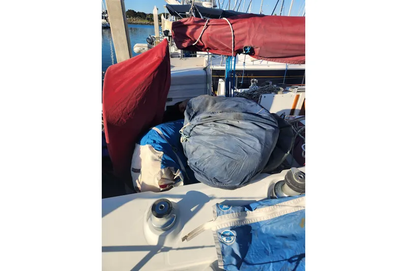 Slide: The Image of 1988 Beneteau First 405 sailboat deck with sails and winches in marina. - 55