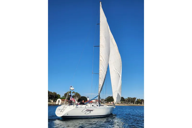 Slide: The Image of 1988 Beneteau First 405 sailboat on water, sails up, clear blue sky. - 6