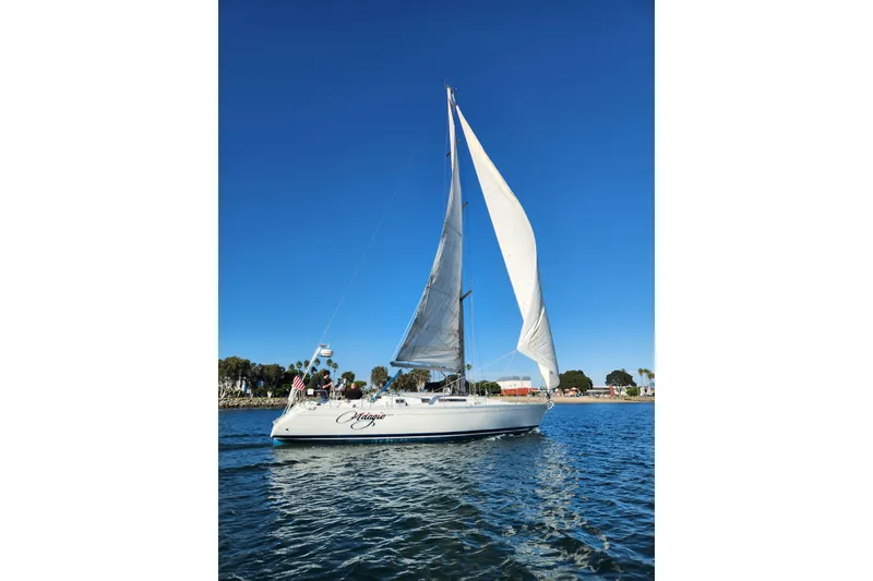 Slide: The Image of 1988 Beneteau First 405 sailboat on calm water under clear blue sky. - 7