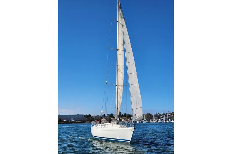 Slide: The Image of 1988 Beneteau First 405 sailboat on open water under clear blue sky. - 8
