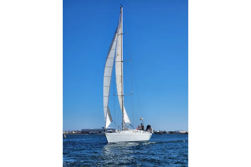 Slide: The Image of Sailing yacht Beneteau First 405, 1988 model, gliding on blue waters under clear skies. - 9