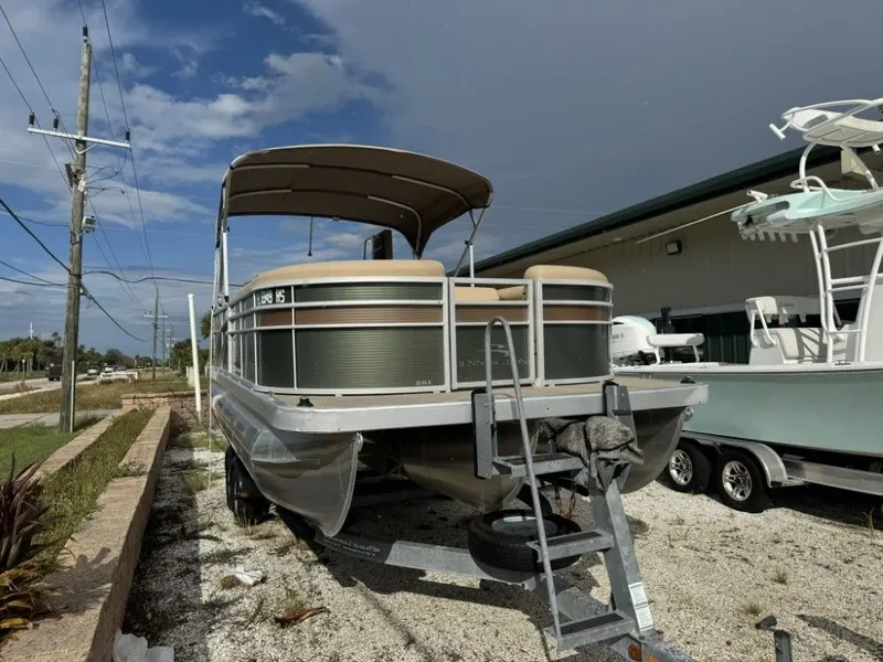 Slide: The Image of 2018 Bennington 21 SLX pontoon boat on trailer, parked outdoors under cloudy sky. - 4