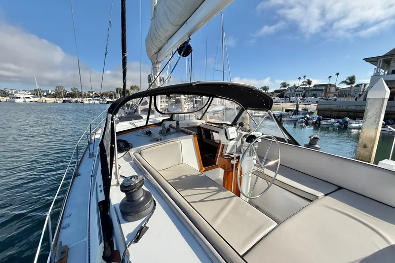 Slide: The Image of 1973 CAL 246 sailboat cockpit with steering wheel, docked in a sunny marina. - 10