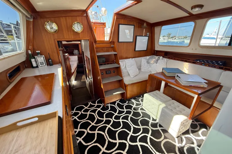 Slide: The Image of 1973 CAL 246 yacht interior with wooden decor, cozy seating, and nautical accents. - 14