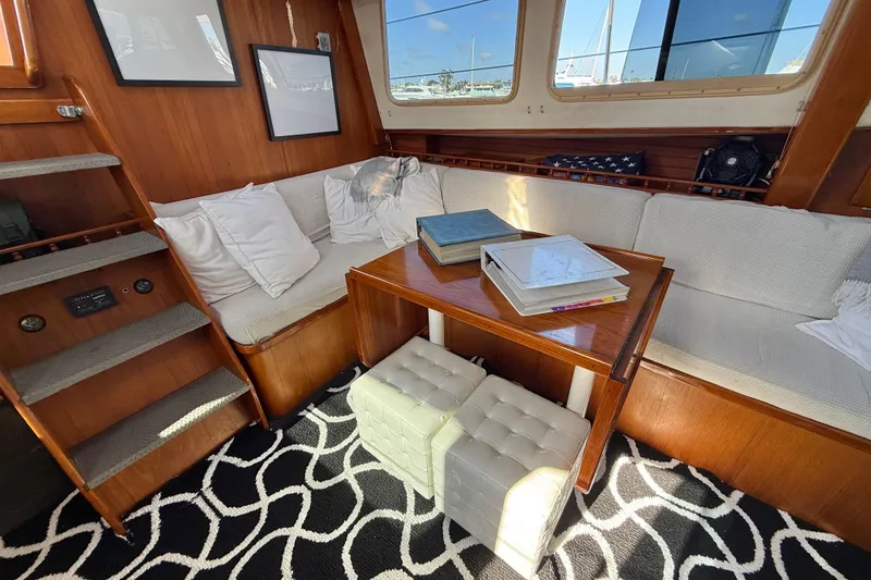 Slide: The Image of Cozy 1973 CAL 246 yacht interior with wooden decor, white seating, and nautical accents. - 16