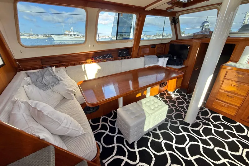 Slide: The Image of Cozy 1973 CAL 246 yacht interior with wooden table, cushioned seating, and nautical decor. - 18