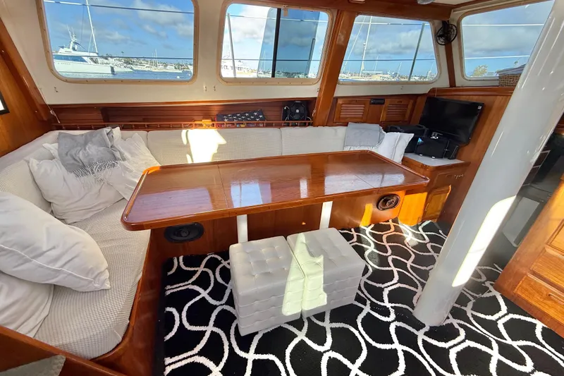 Slide: The Image of Cozy 1973 CAL 246 yacht interior with wooden table, cushioned seating, and nautical decor. - 19
