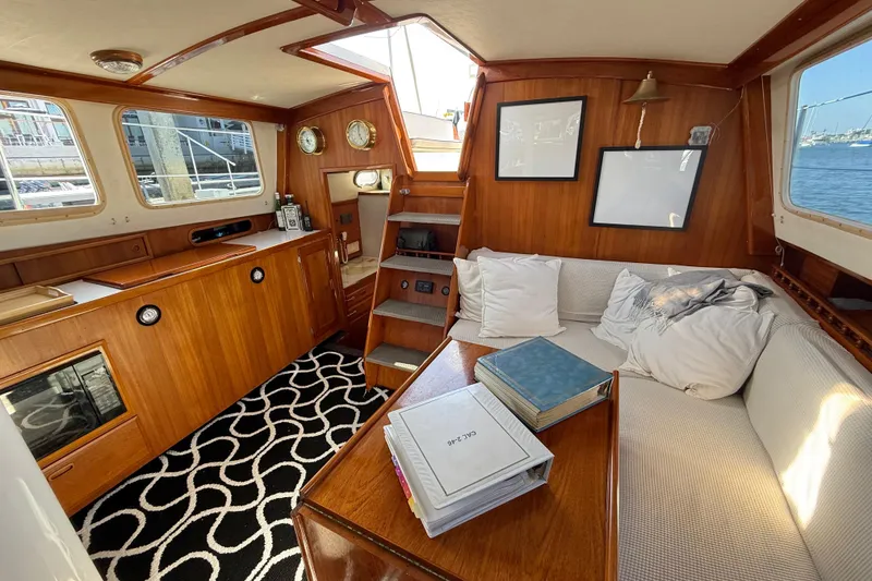 Slide: The Image of 1973 CAL 246 yacht interior with wood paneling, cozy seating, and nautical decor. - 25