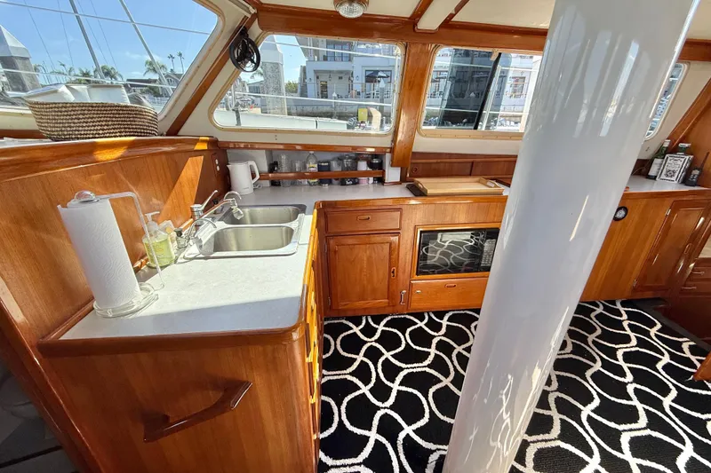 Slide: The Image of 1973 CAL 246 yacht interior with wooden cabinetry, modern kitchen, and nautical decor. - 28