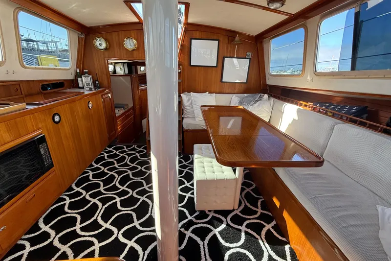 Slide: The Image of 1973 CAL 246 yacht interior with wooden furnishings, patterned carpet, and large windows. - 29