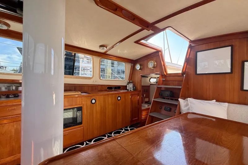Slide: The Image of 1973 CAL 246 yacht interior with wooden cabinetry, windows, and nautical decor. - 31