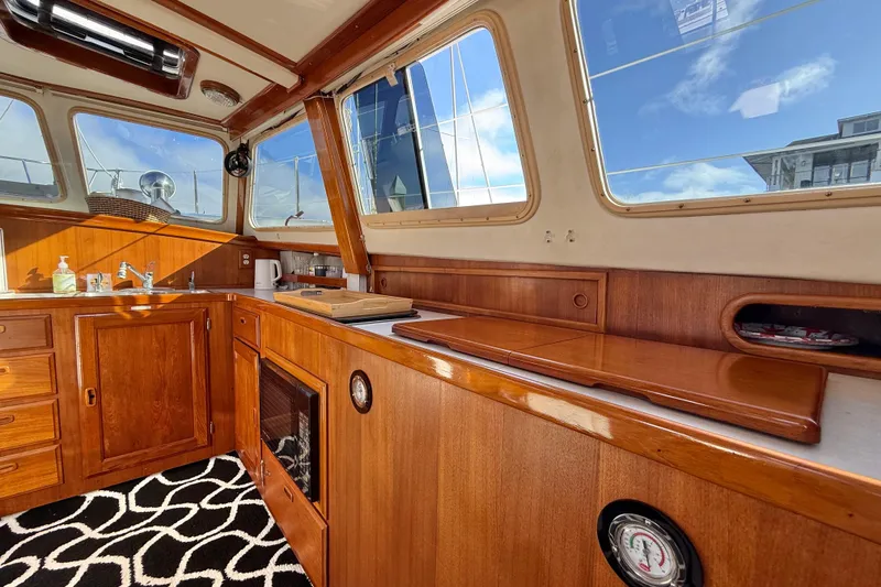 Slide: The Image of 1973 CAL 246 boat interior with wooden cabinetry, sink, and nautical decor. - 32