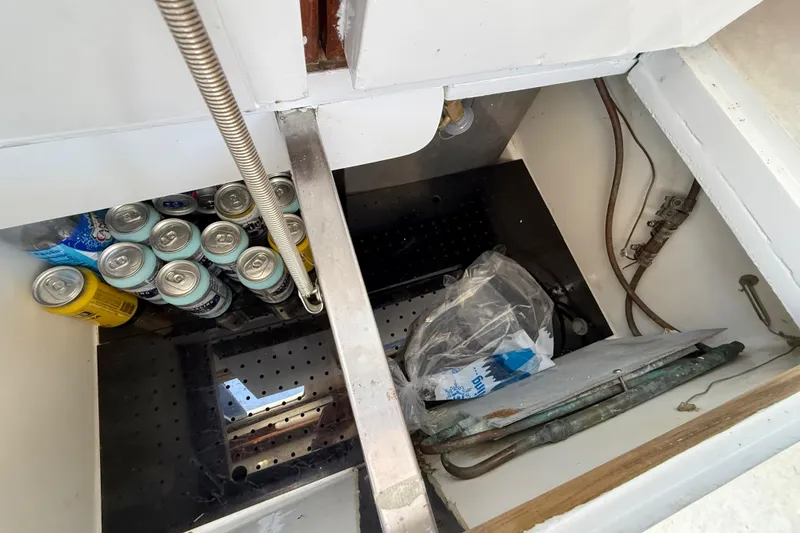 Slide: The Image of Storage compartment in a 1973 CAL 246 boat with beverage cans and miscellaneous items. - 39