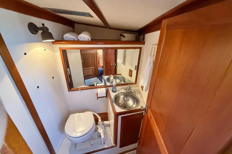 Slide: The Image of 1973 CAL 246 yacht bathroom with wooden accents, mirror, sink, and toilet. - 45
