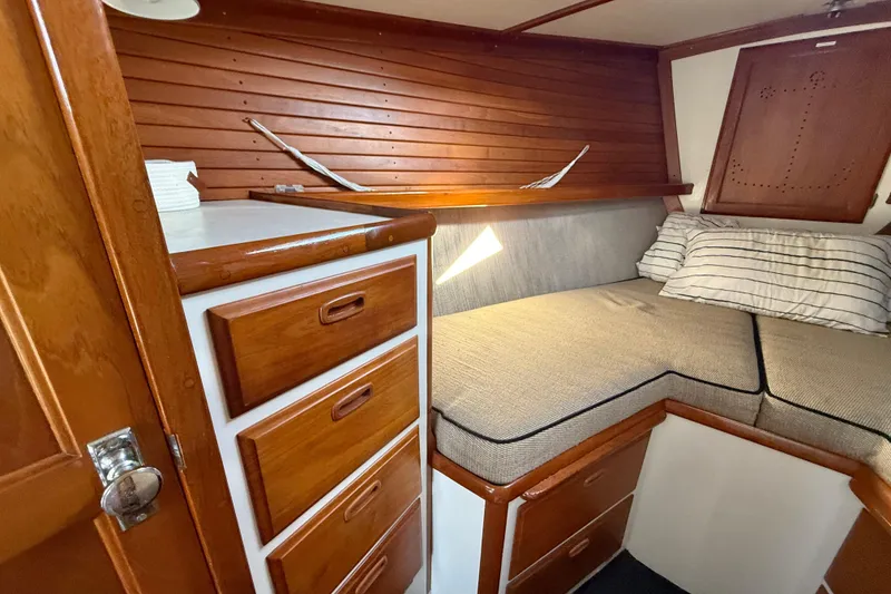 Slide: The Image of 1973 CAL 246 boat interior with wooden cabinets and cozy sleeping area. - 49