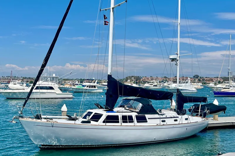 Slide: The Image of 1973 CAL 246 sailboat docked in a marina, surrounded by other boats under a clear blue sky. - 5
