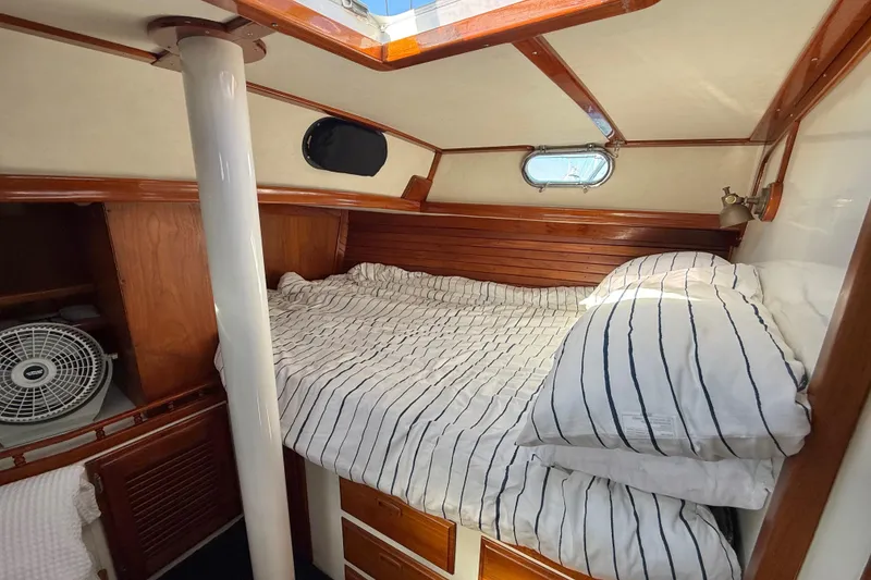 Slide: The Image of Cozy cabin interior of 1973 CAL 246 sailboat with striped bedding and wooden accents. - 57