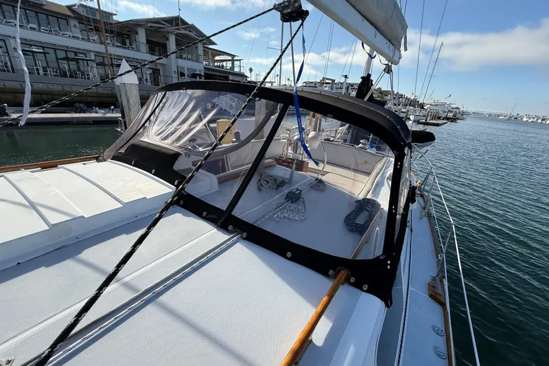 Slide: The Image of 1973 CAL 246 sailboat docked at marina, featuring sleek design and clear canopy. - 68