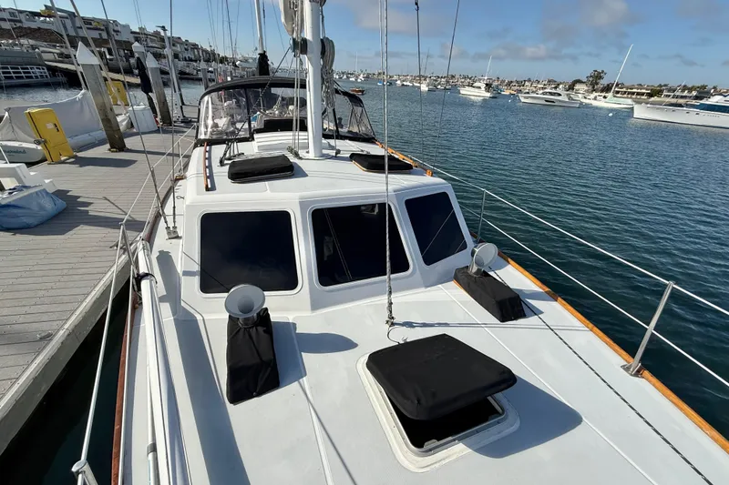 Slide: The Image of 1973 CAL 246 sailboat docked at marina, surrounded by calm water and other boats. - 69
