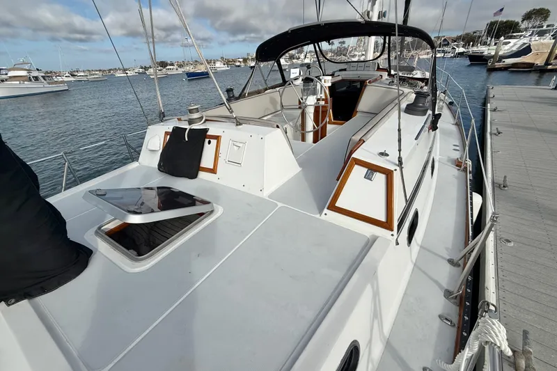 Slide: The Image of 1973 CAL 246 sailboat docked at marina, featuring spacious deck and sleek design. - 7