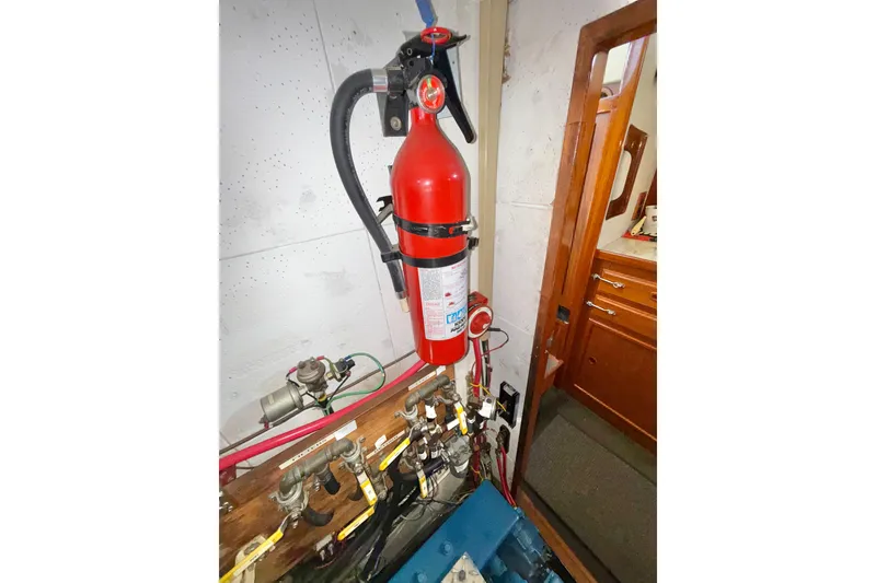 Slide: The Image of Red fire extinguisher mounted in a 1973 CAL 246 boat interior. - 73
