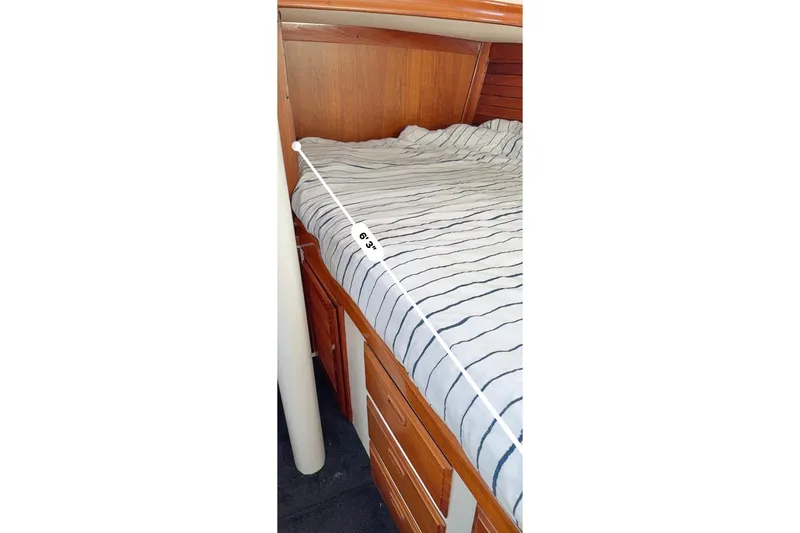 Slide: The Image of 1973 CAL 246 boat cabin with striped bedding, measuring 6'3" in length. - 76