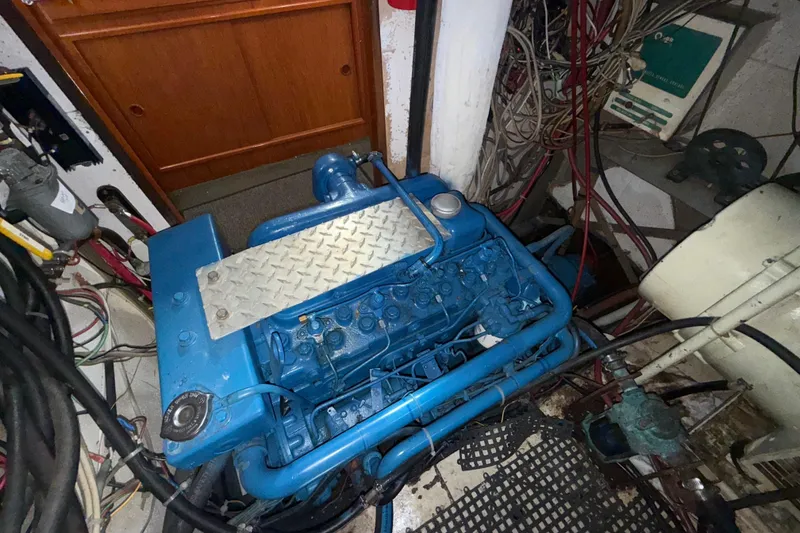 Slide: The Image of 1973 CAL 246 engine in a cluttered mechanical room with cables and equipment. - 79