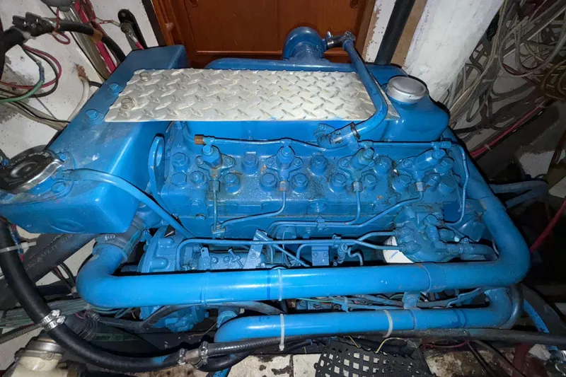 Slide: The Image of Blue 1973 CAL 246 engine with visible pipes and components in a mechanical setting. - 81