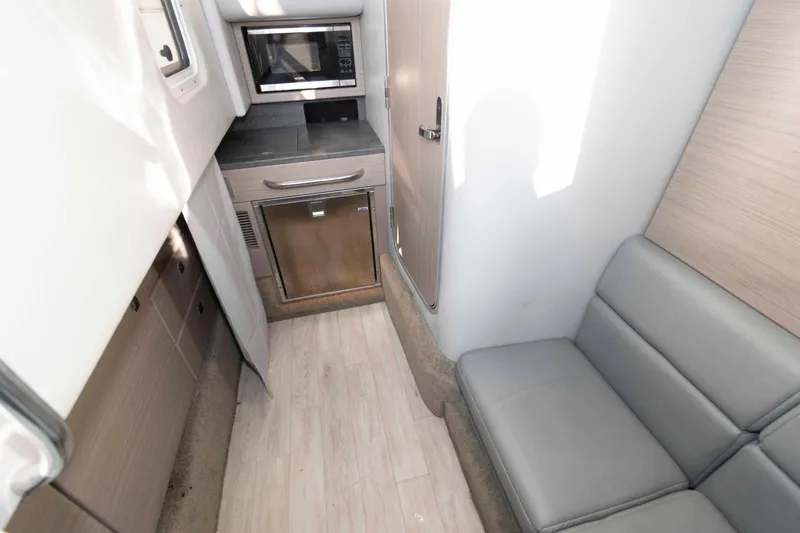 Slide: The Image of 2018 Formula 350 Crossover Bowrider interior with kitchenette and seating area. - 16