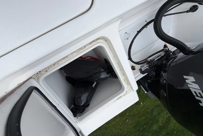 Slide: The Image of 2023 Sea Pro 219 Center Console boat storage compartment with gear and engine details. - 16
