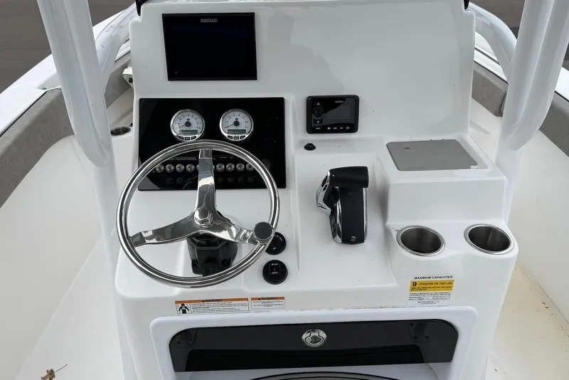 Slide: The Image of 2023 Sea Pro 219 Center Console boat dashboard with steering wheel and controls. - 20