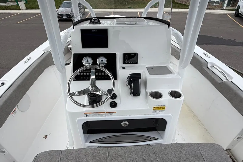 Slide: The Image of 2023 Sea Pro 219 Center Console boat dashboard with steering wheel and controls. - 21