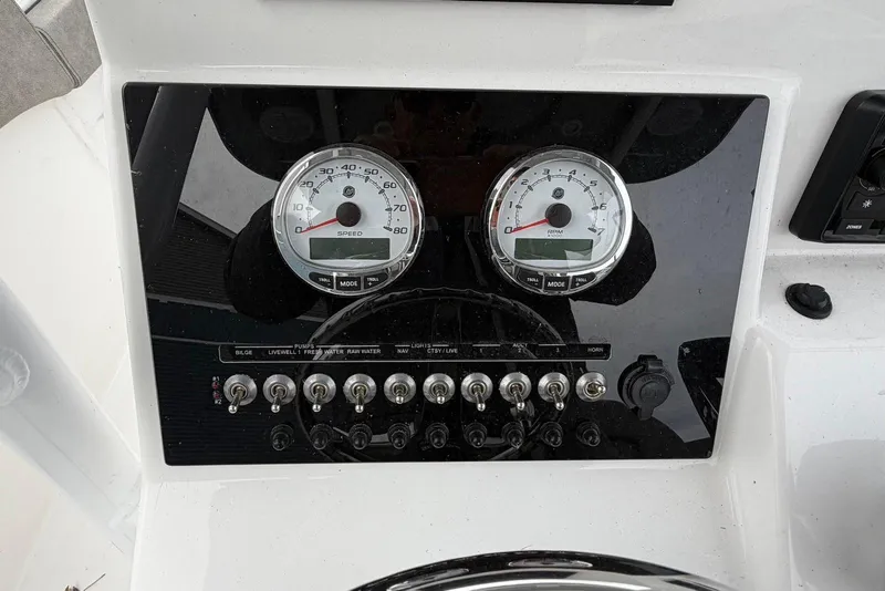 Slide: The Image of 2023 Sea Pro 219 Center Console dashboard with speedometer and control switches. - 24