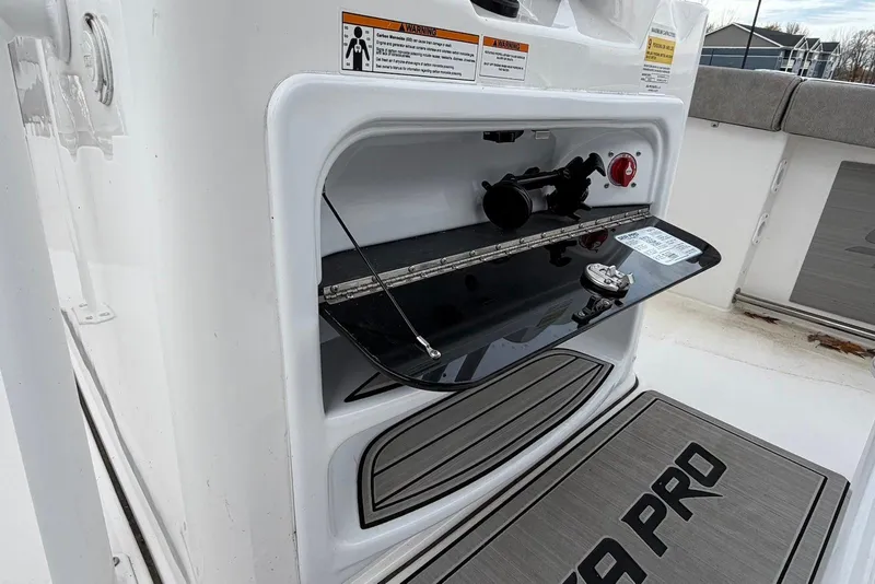 Slide: The Image of 2023 Sea Pro 219 Center Console boat storage compartment with open hatch and safety warnings. - 26