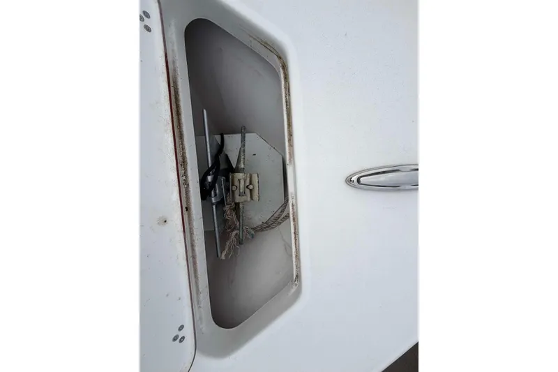 Slide: The Image of 2023 Sea Pro 219 Center Console anchor storage compartment with visible anchor and rope. - 33