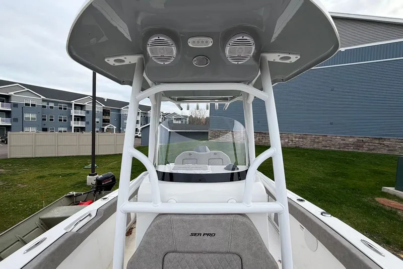 Slide: The Image of 2023 Sea Pro 219 Center Console boat with T-top, parked near residential buildings. - 39