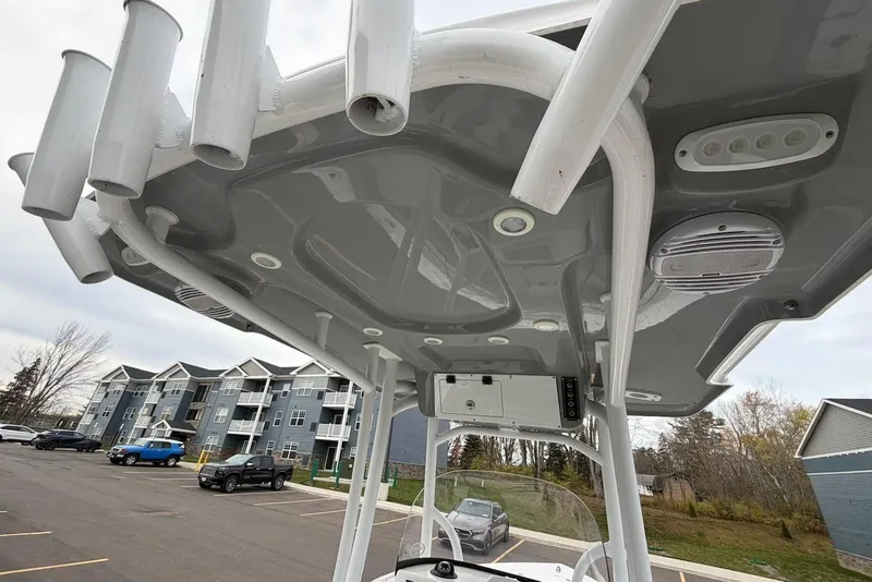 Slide: The Image of 2023 Sea Pro 219 Center Console boat with rod holders and speakers, parked near residential buildings. - 40